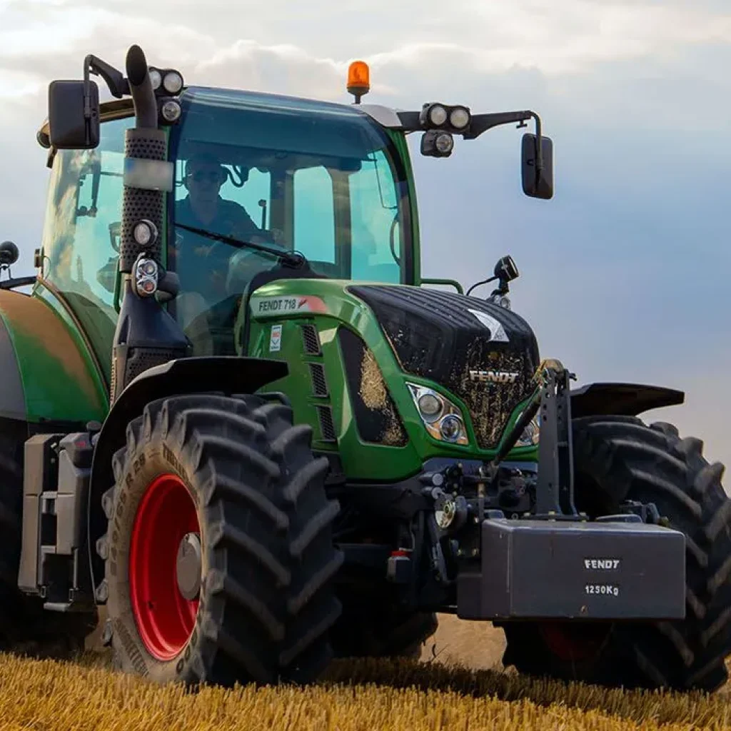 green tractor plowing the fields